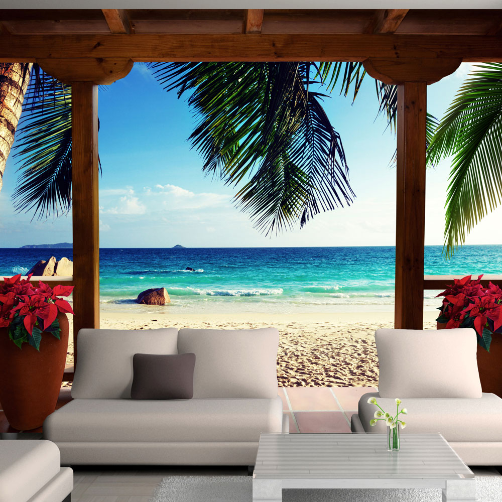 ARTGEIST Fototapet med motiv af feriehus med terrasse ved strand med palmer (flere størrelser) 100x70